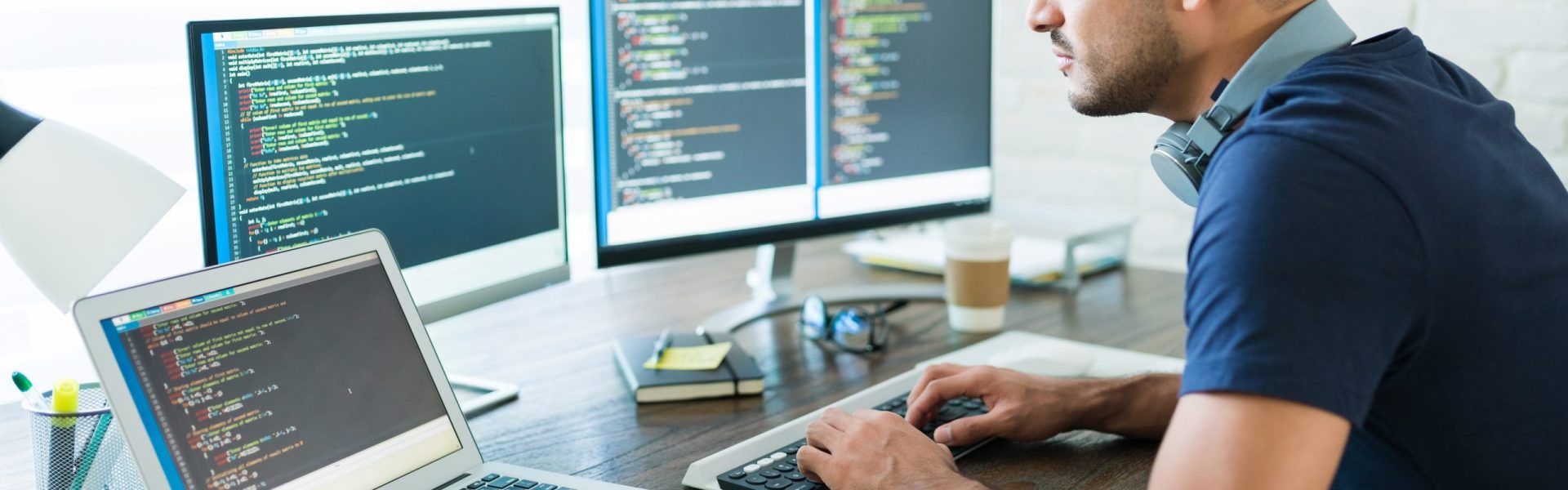 Side view of attractive Hispanic software developer programming using computer while working from home